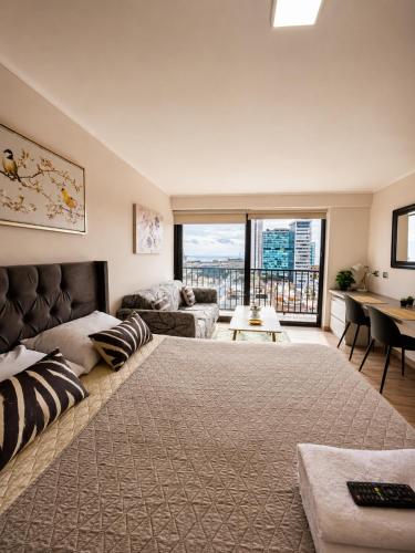 a large bedroom with a large bed and a couch at Centro Vista Al Mar san Martin Coliving in Antofagasta