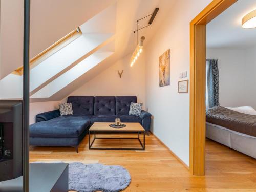 a living room with a blue couch and a table at Bösenstein in Hohentauern