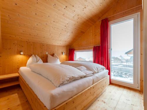 a bed in a wooden room with a window at Bärenschanze in Hohentauern