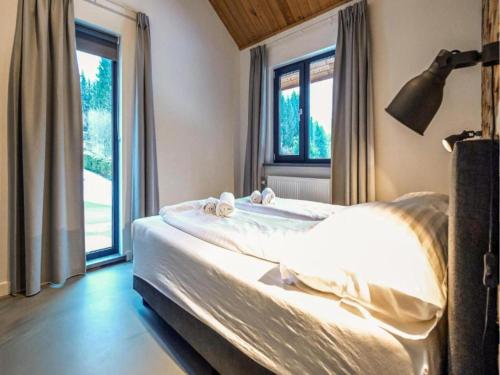 a bedroom with a bed and a large window at SeeZeit am Pressegger See in Lake Pressegg