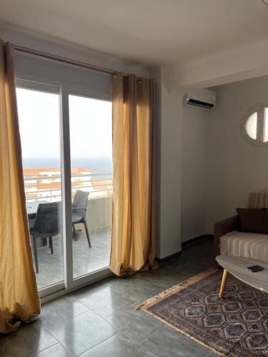 a living room with a couch and a sliding glass door at T2 vue sur mer in Bejaïa
