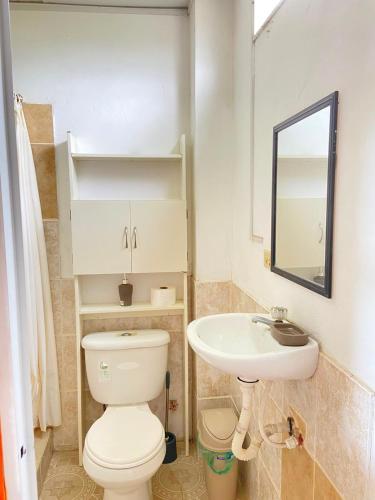 a bathroom with a toilet and a sink at Hostería del Puerto in Puerto López