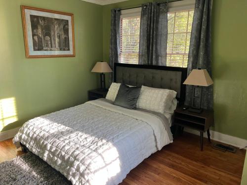 a bedroom with a large bed and two windows at Cute 2 bedroom home ! in Augusta