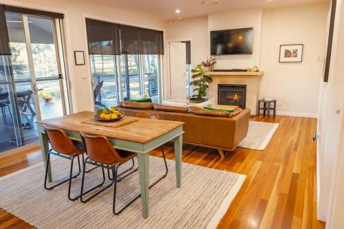 a living room with a table and a couch at Fig Tree Luxury Guest House in Pokolbin