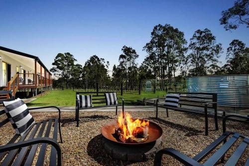 a fire pit in a yard next to two benches at Lamp Estate in Greta