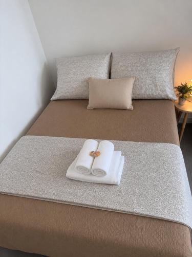 a bed with two towels and two rings on it at Studio in Barbacena
