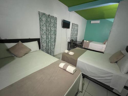 a small room with two beds and a mirror at Hotel Comfort Trujillo in La Milagrosa