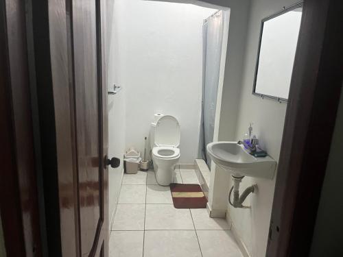 a white bathroom with a toilet and a sink at Hotel Comfort Trujillo in La Milagrosa
