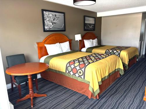 a hotel room with two beds and a table at Seven Oakes Motel in Kingston