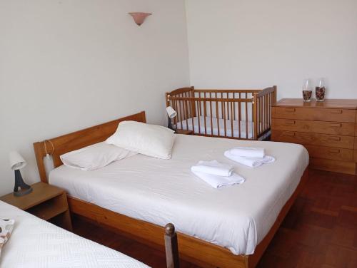 a bedroom with two beds with white sheets and towels at Casa D'Afife in Afife
