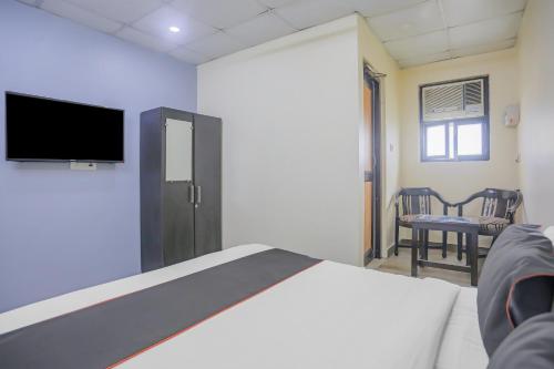 a bedroom with a bed and a tv and a chair at Collection O Green Park Residency 3 in New Delhi