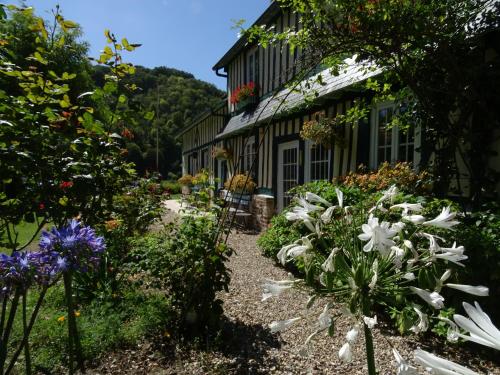 a garden in front of a house with flowers at Chambre d'hôtes Au Fil De L'eau in Jumièges