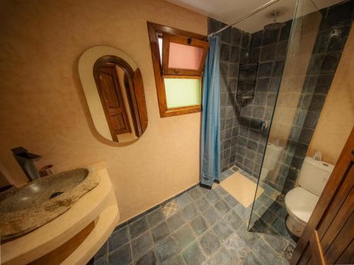 a bathroom with a sink and a shower and a toilet at The Cove Surf House in Tamraght Ouzdar