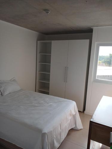 a bedroom with a white bed and a window at Departamento en Condominio in Luque