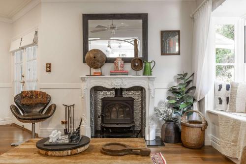 a living room with a fireplace and a mirror at Antara House by Coast Hosting in Matcham