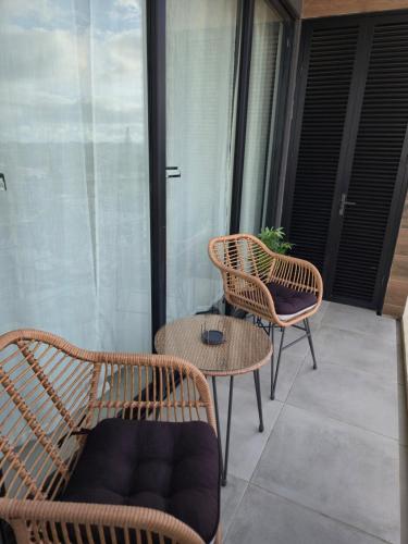 two wicker chairs and a table on a balcony at City View Luxe Condo in Mandeville