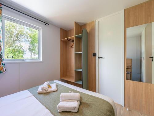 a bedroom with a bed with towels on it at New Vennepark caravan 463 6p in De Haan