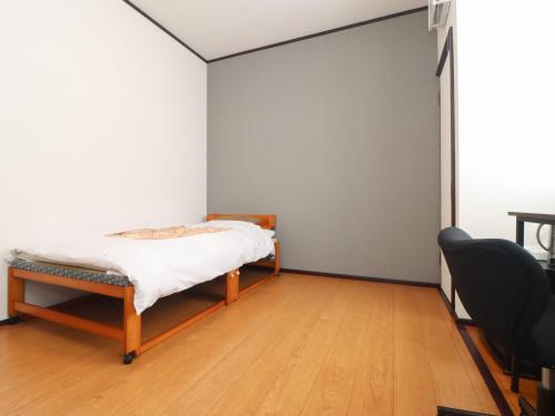 a bedroom with a bed and a chair in it at サンバレーひぐち in Muikamachi