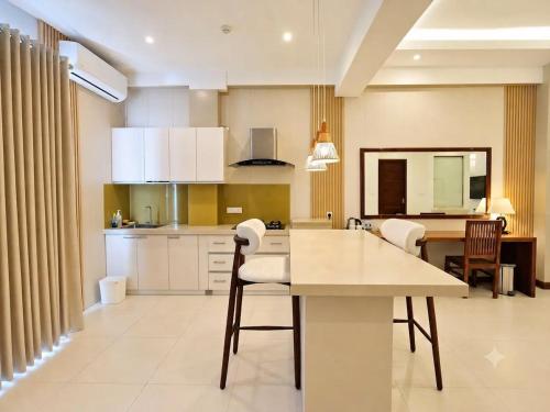a kitchen with white cabinets and a table and chairs at Apna Colombo in Nawala