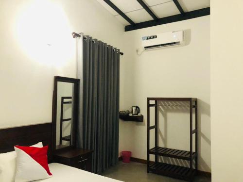 a bedroom with a bed and a curtain and a mirror at wild elephant reach wilpattu in Nochchiyagama