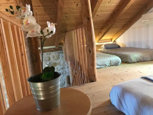 a room with two beds and a table with a vase with flowers at Lucica 1 Beachfront House in Lastovo