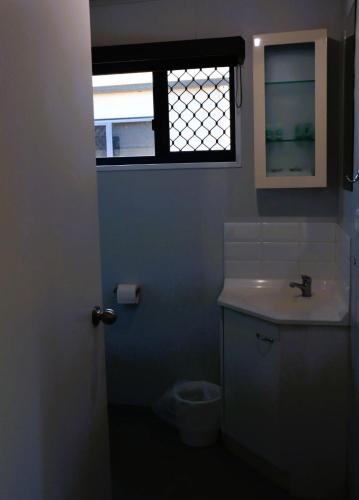 a bathroom with a toilet and a sink and a window at The Hotel Pioneer Brandon in Brandon
