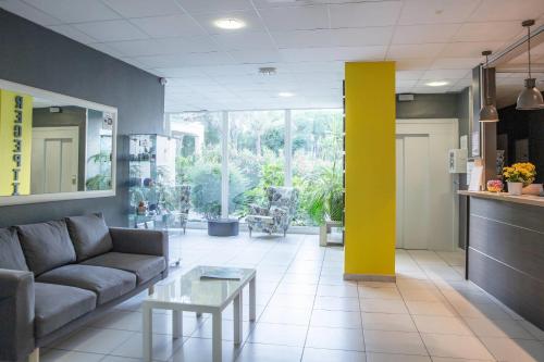 a living room with a couch and a table at Comfort Aparthotel Frejus La Tour de Mare in Fréjus