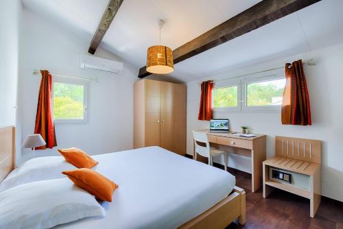 a bedroom with a bed and a desk with a computer at Comfort Aparthotel Mandelieu la Napoule Village in Mandelieu-La Napoule
