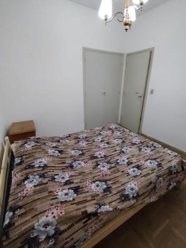 a bedroom with a bed with flowers on it at Tucumán y Colón in Mar del Plata