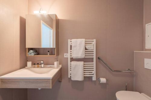 a bathroom with a sink and a mirror and a toilet at Quality Aparthotel Moissy-Cramayel in Moissy-Cramayel