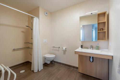 a bathroom with a toilet and a sink and a mirror at Quality Aparthotel Rochefort in Rochefort