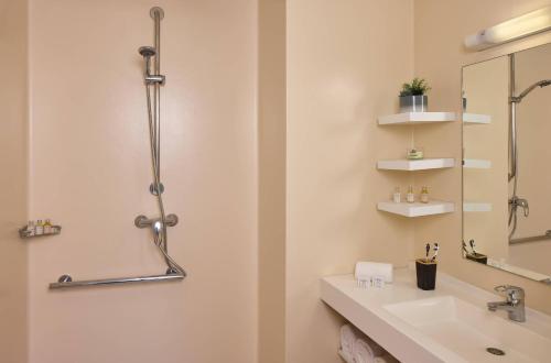 a bathroom with a sink and a mirror at Quality Aparthotel Valenciennes in Valenciennes