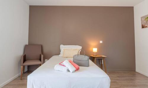 a bedroom with a white bed with towels on it at Quality Aparthotel Lyon L'Isle-d Abeau in LʼIsle-dʼAbeau
