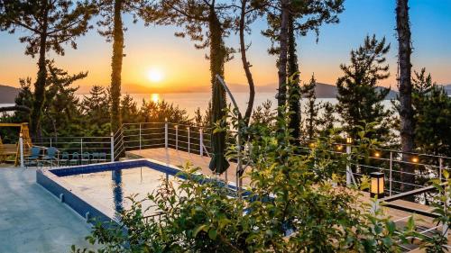 a swimming pool with a sunset in the background at Yeosu Sky Pension in Yeosu