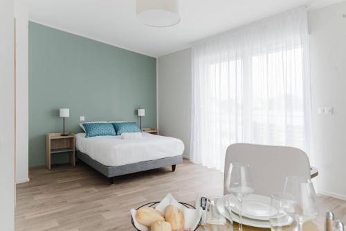 a bedroom with a bed and a table with a plate of bread at Quality Aparthotel Quiberon in Quiberon