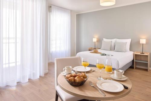 a bedroom with a bed and a table with food on it at Quality Aparthotel Cherbourg in Cherbourg en Cotentin