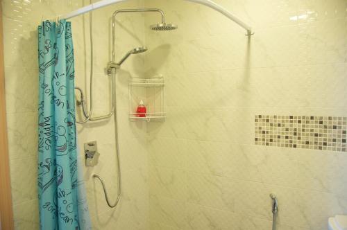 prysznic z niebieską zasłoną w łazience w obiekcie Acqua Apartment w mieście Jomtien Beach