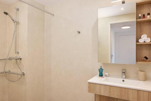 a bathroom with a sink and a shower at Quality Aparthotel Ploërmel in Ploërmel