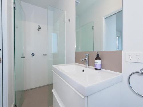 a white bathroom with a sink and a shower at 41 Ocean in Anna Bay