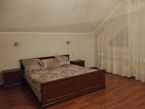 a bedroom with a bed and a large window at Дом in Odesa