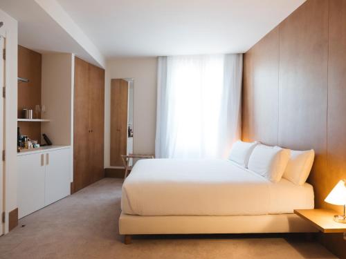 a bedroom with a white bed and a window at Círculo Condal in Barcelona