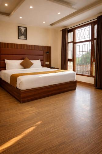 a bedroom with a large bed and a large window at Kaisha Himalayan View in Shimla