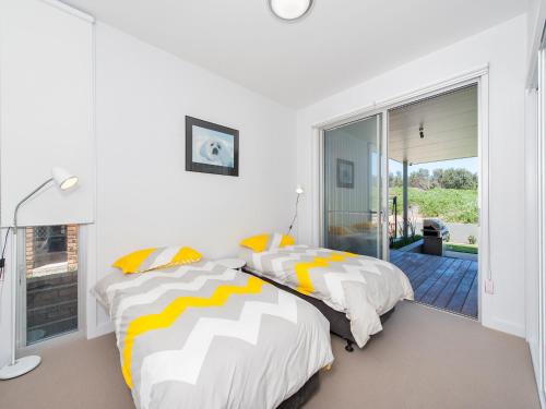 a bedroom with two beds and a sliding glass door at 41 Ocean in Anna Bay