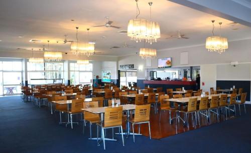 a dining room with tables and chairs and chandeliers at The Hotel Pioneer Brandon in Brandon