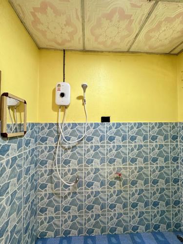a shower in a bathroom with blue and white tiles at Thai Style House - Yao Noi in Ko Yao Noi