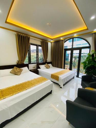 two beds in a hotel room with windows at Hotel 24h in Hai Phong