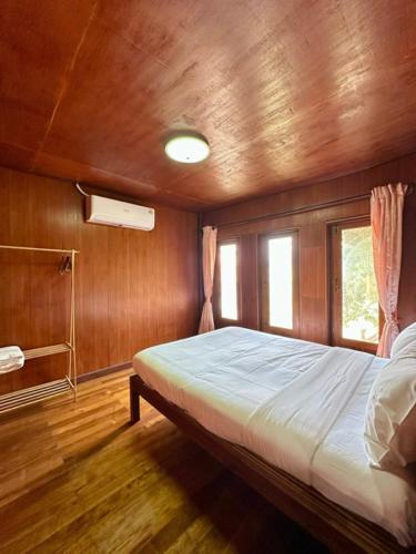 a bedroom with a bed in a wooden room at Thai Style House - Yao Noi in Ko Yao Noi