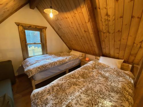 two beds in a room with a window at Resort Door in Yamanakako