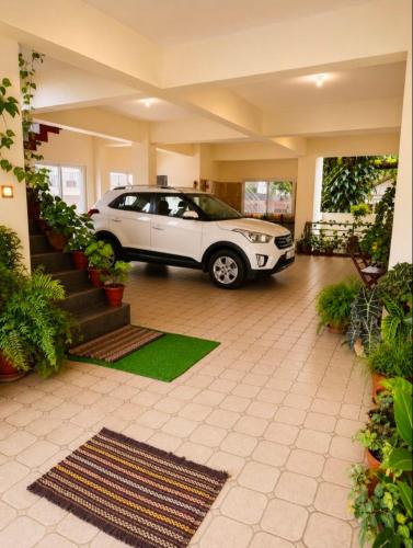 a white car parked inside of a house at The two bedroom house in Madikeri