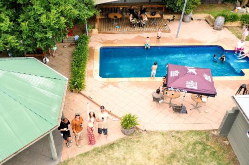 a group of people standing around a swimming pool at Harrietville Hotel Motel in Harrietville
